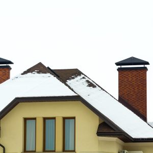Low angle view of the upper floors of a new large house. Window and roof detail of residential home building. Real estate property.